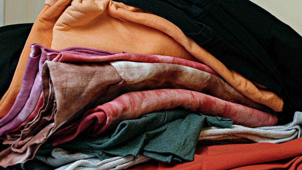 selective focus photo of multicolored textile fabric samples. serigraphy production. printing images on t-shirts by silkscreen method in a design studio